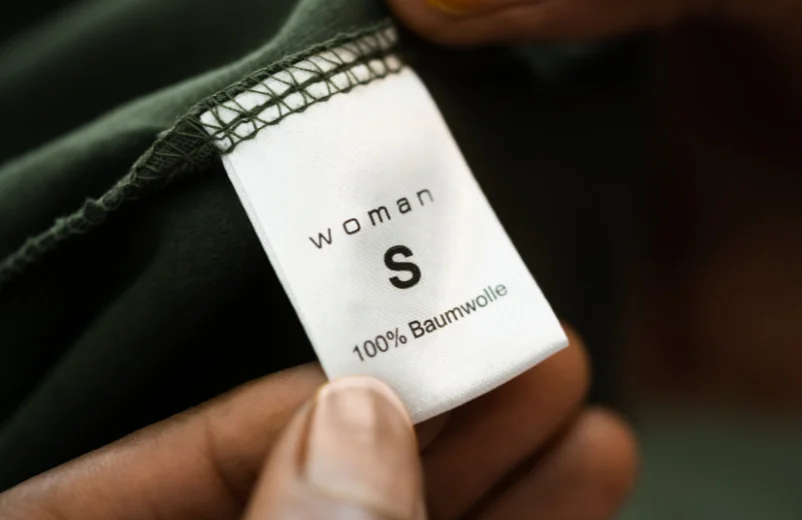 Close-up of a garment label reading woman, size S, 100% cotton