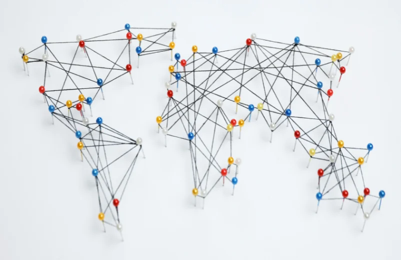 World map built from pins and thread showing connections between continents