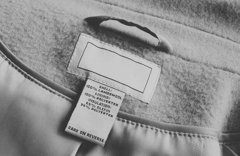Composition label sewn inside a wool coat, black and white photo