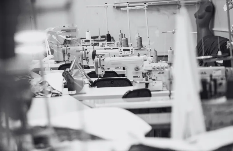 Sewing workshop with industrial machines and a dress form, black and white photo