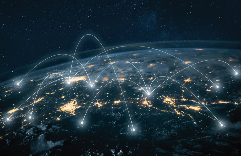 Vista nocturna del globo con arcos de luz que conectan ciudades, imagen del comercio global