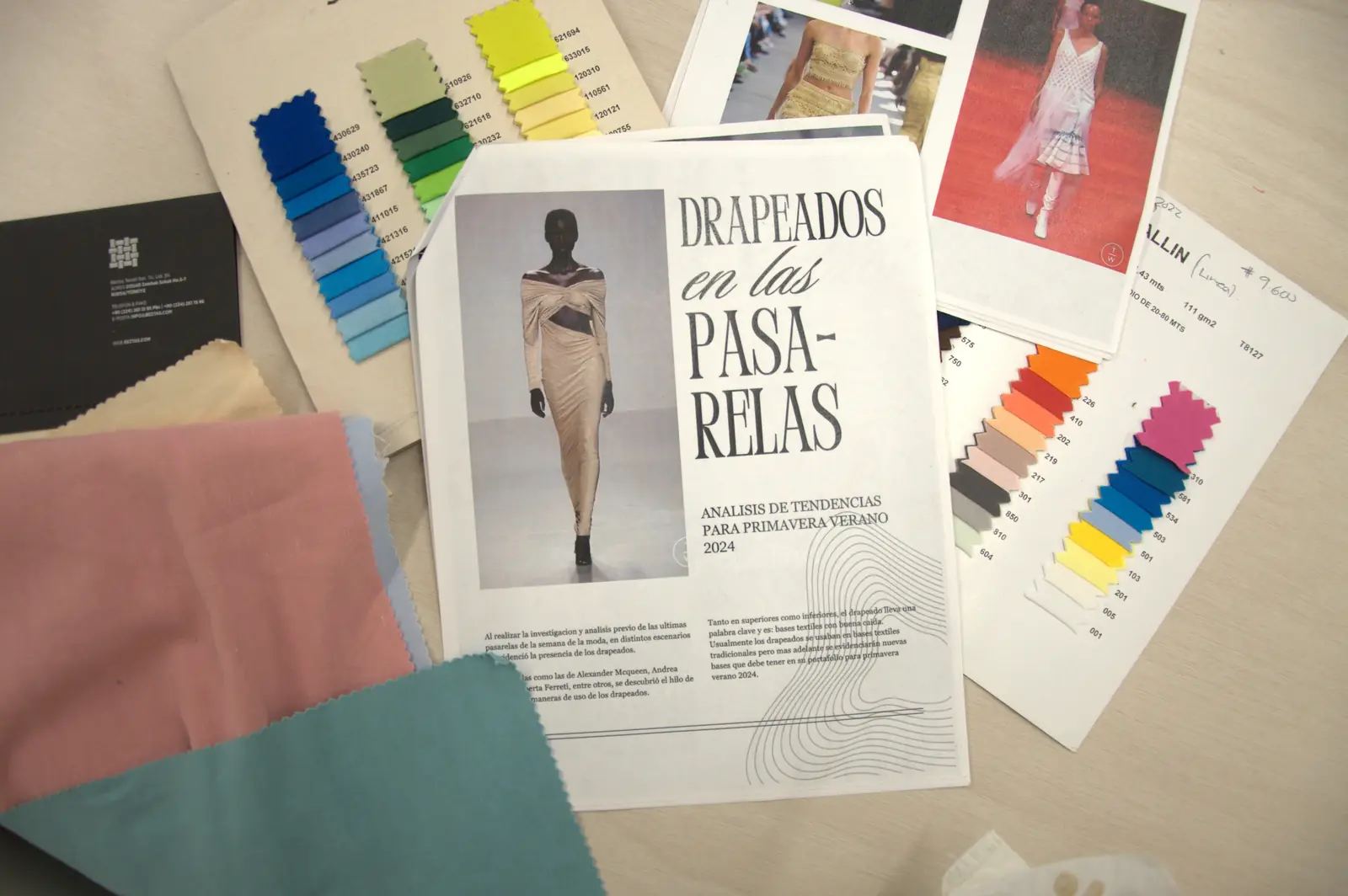GAT design table with color chart, runway tear sheets, and fabric swatches