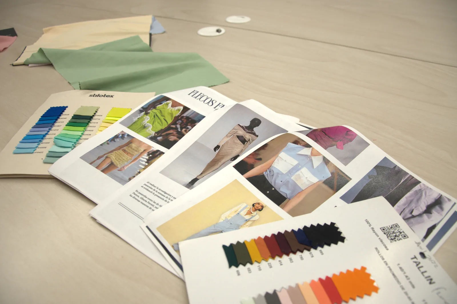 GAT textile design table with fabric swatches and runway trend tear sheets during development