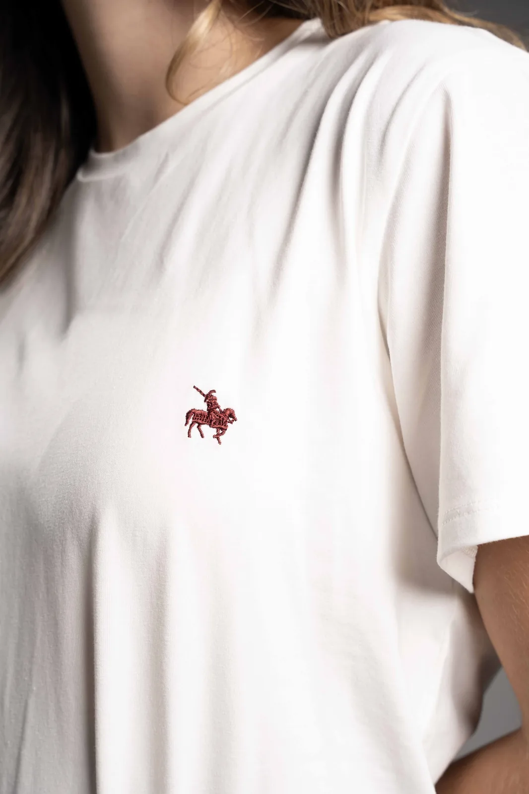 Close-up of a red horseman embroidery on a white t-shirt, a real GAT finish