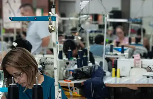 Worker sewing garment on industrial machine at GAT workshop