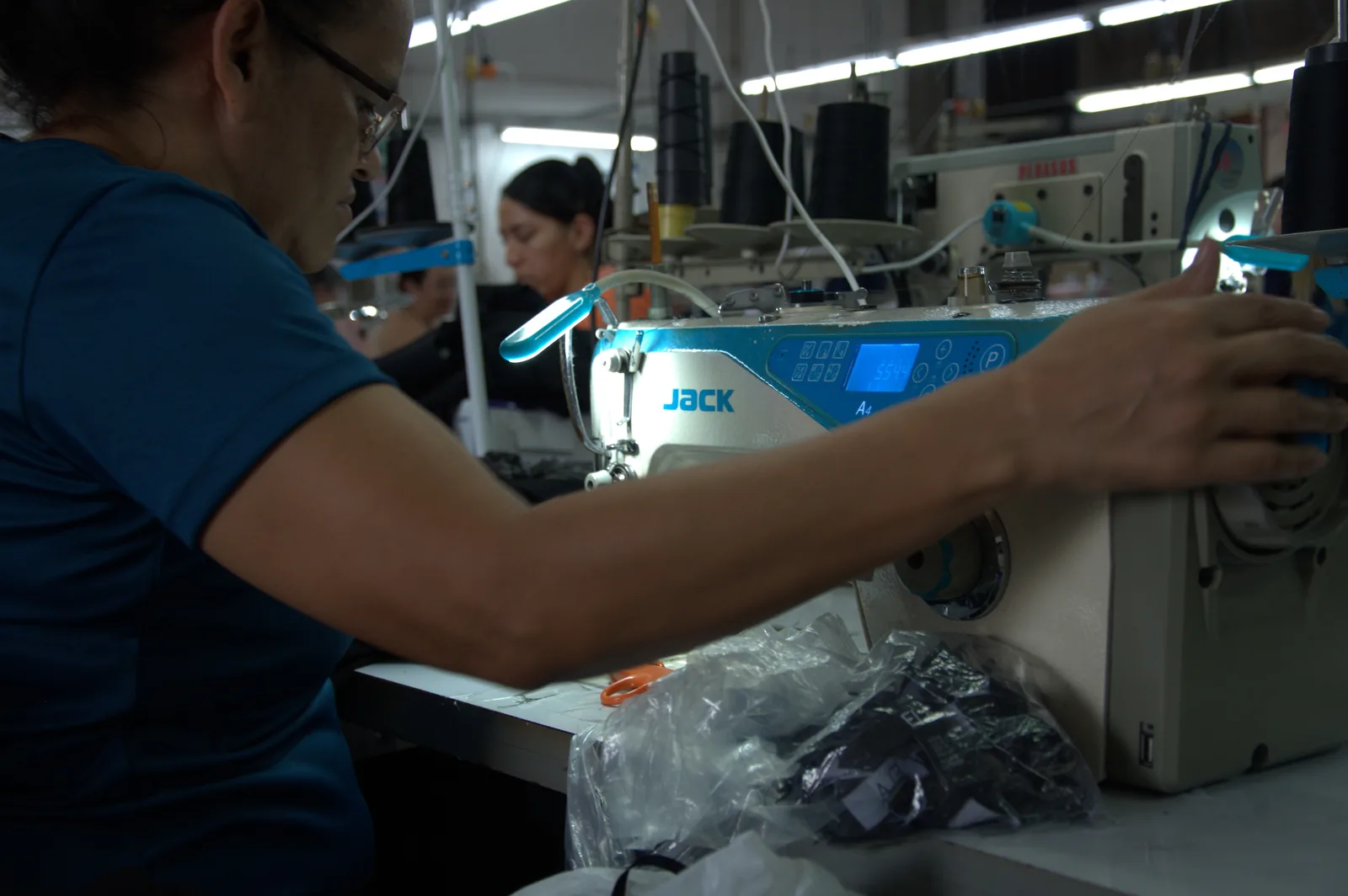 Heat-press machine applying a label to a black garment on the GAT production floor