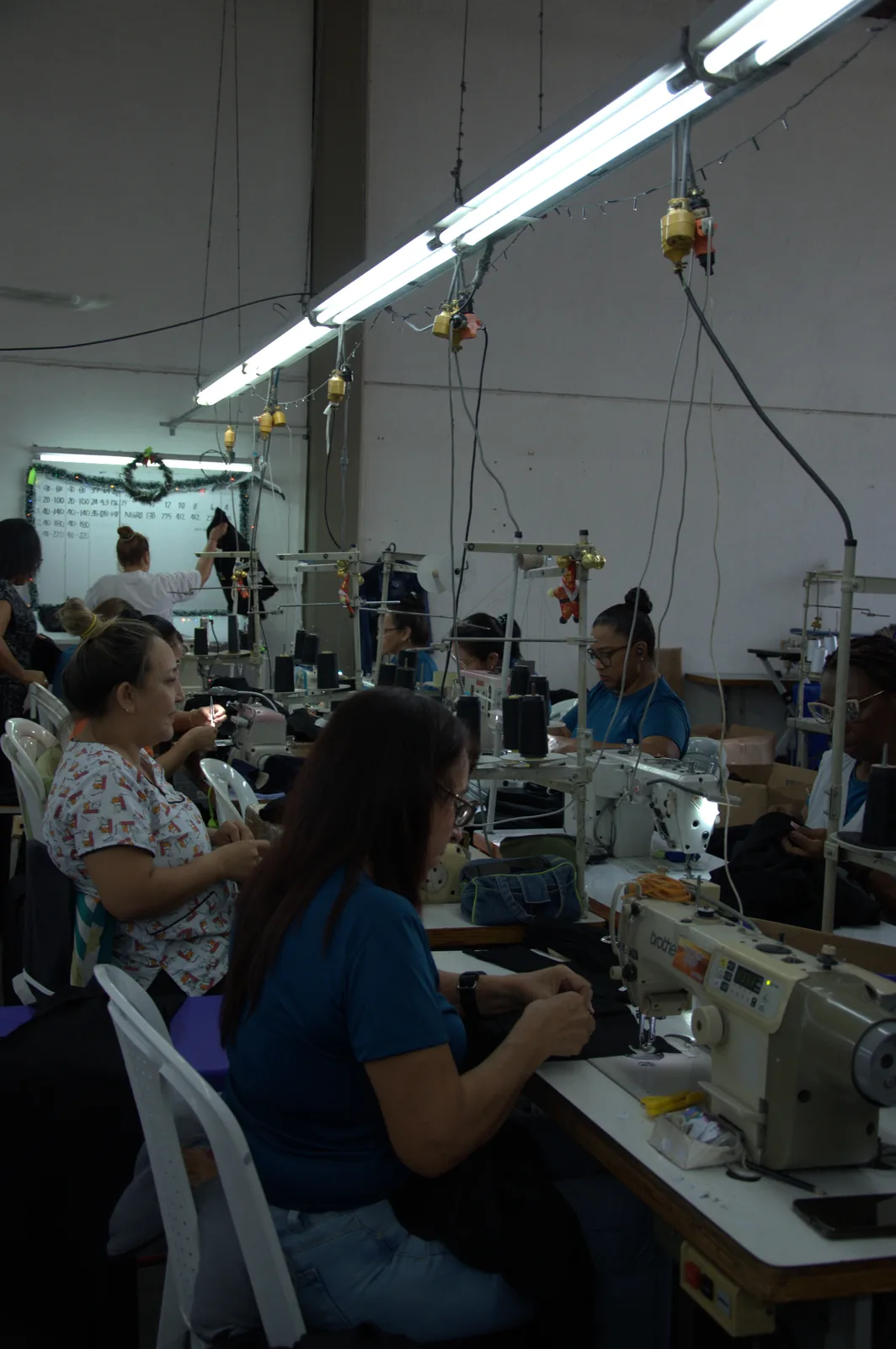 Workers sewing on industrial machines inside the garment workshop