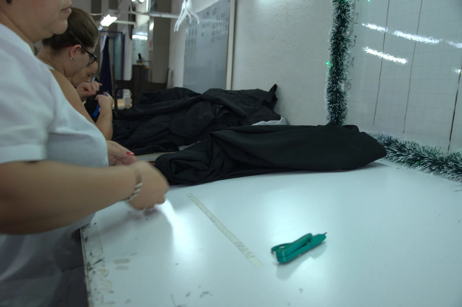 Two GAT workers checking and measuring a garment against the approved measurement chart