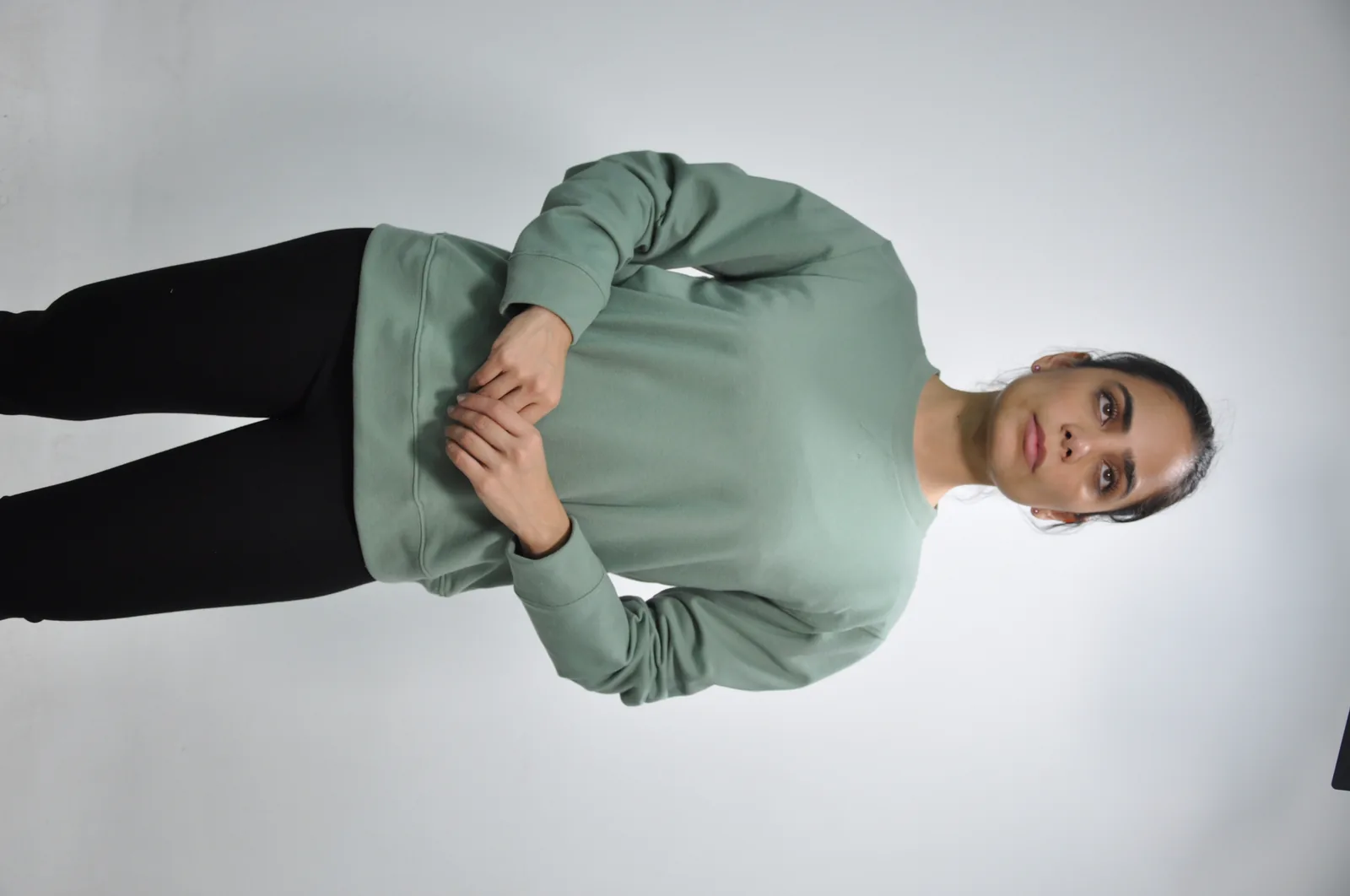 Sudadera verde salvia y legging negro en modelo mujer, vista frontal GAT